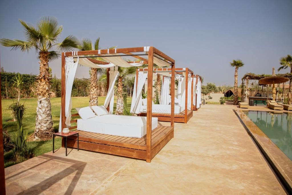 Les lits à baldaquin alignés le long de la piscine