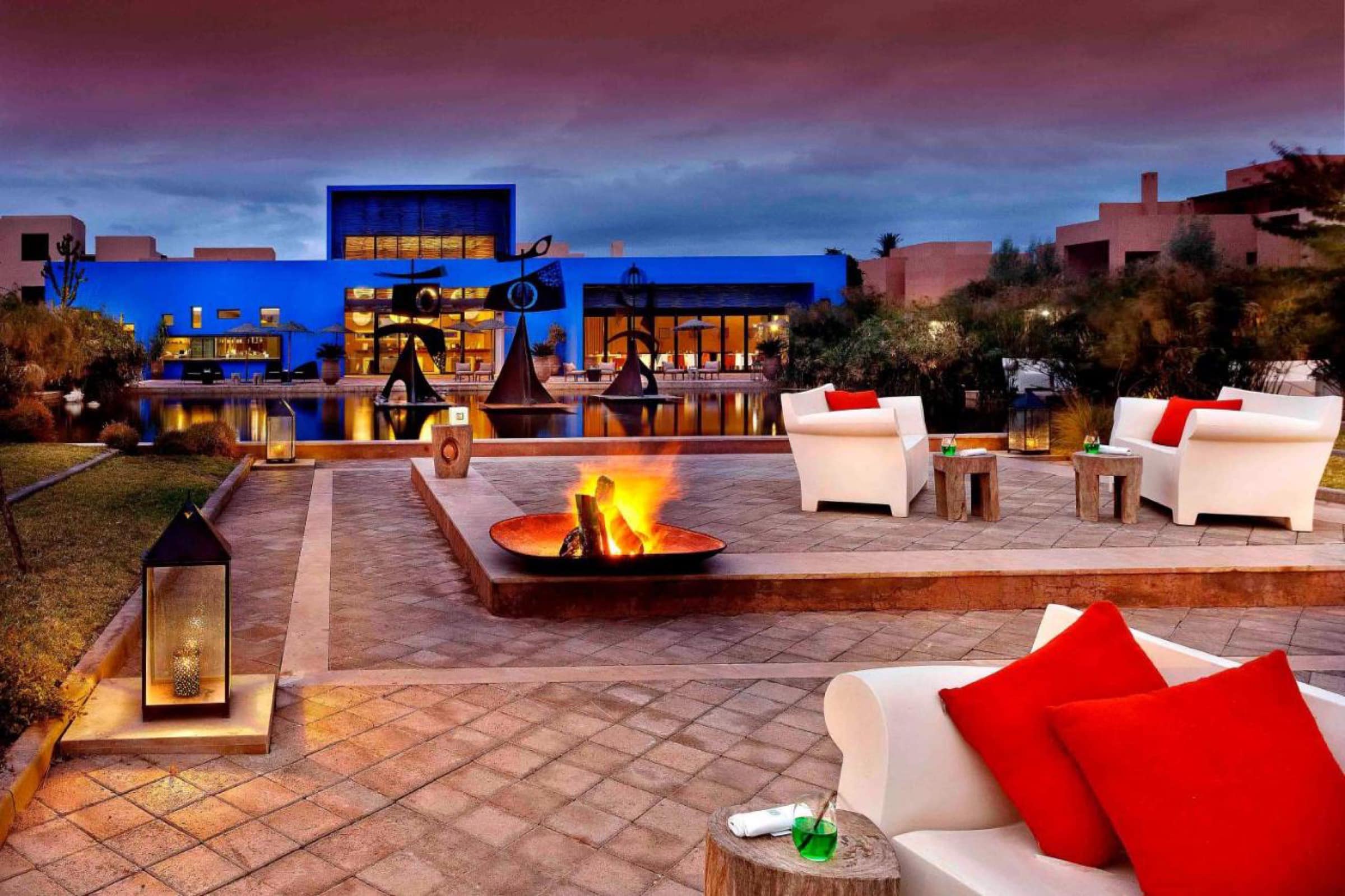 La terrasse au bord de l'eau, sculptures et feu de camp au soir