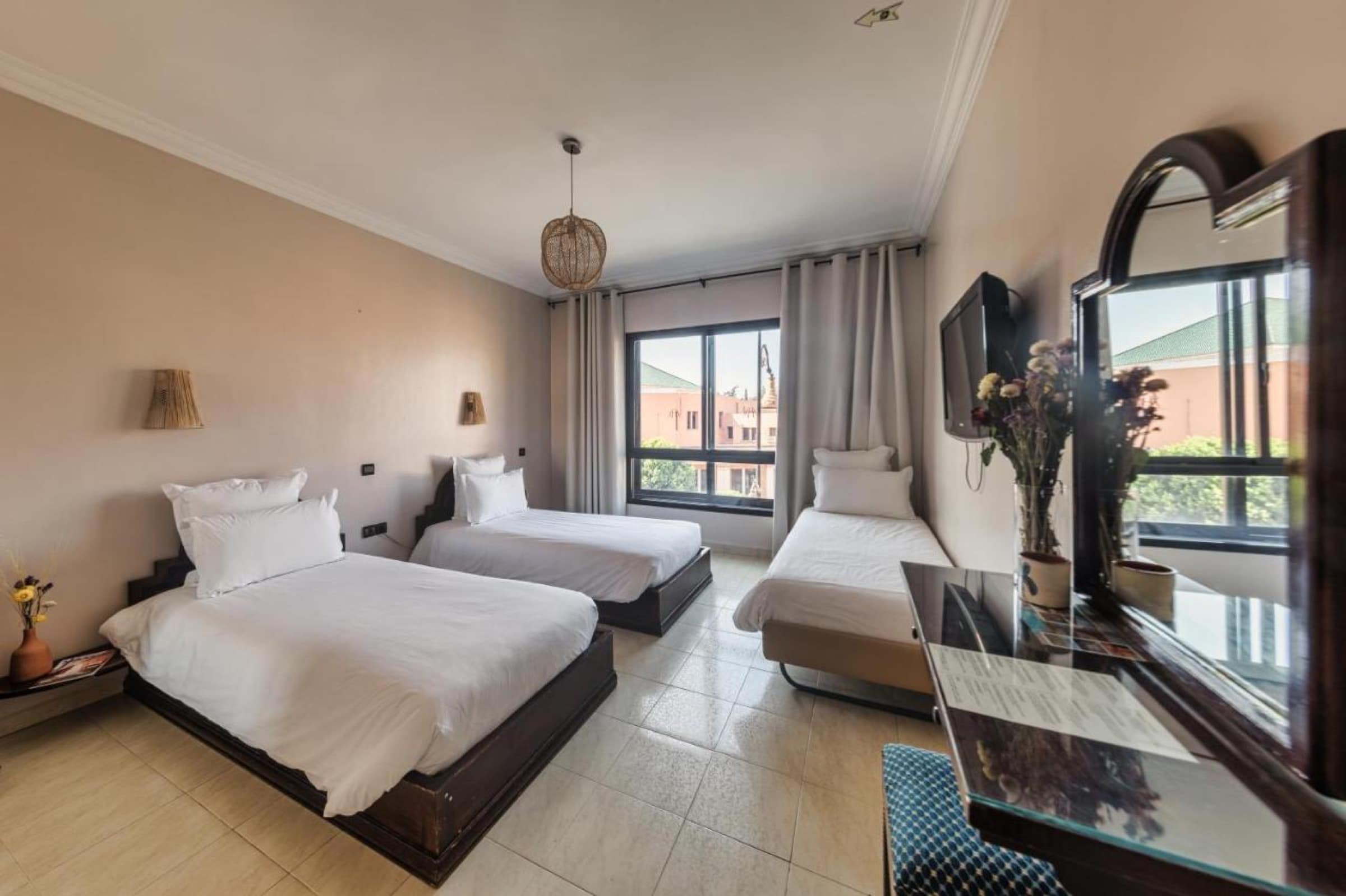 Une chambre triple simple, sol de tomettes et vue sur les toits