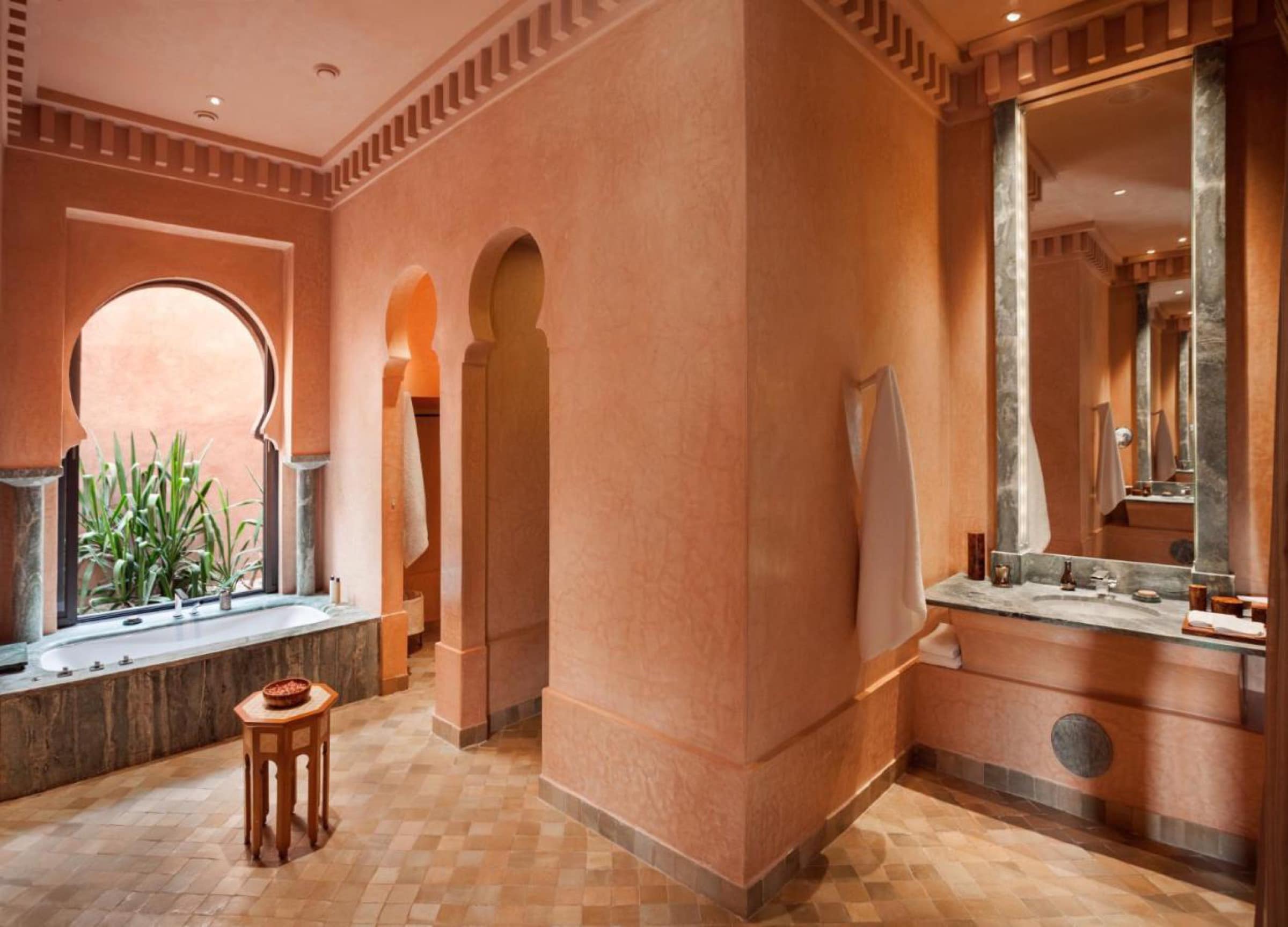 Une salle de bains en tadelakt ocre, baignoire sous arche