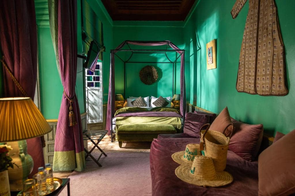 Une chambre verte, lit à baldaquin et salon attenant