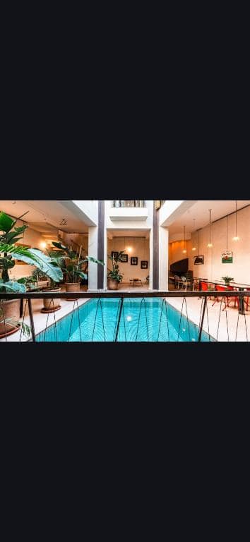 La piscine intérieure, au pied de l'escalier, ouverte sur le salon