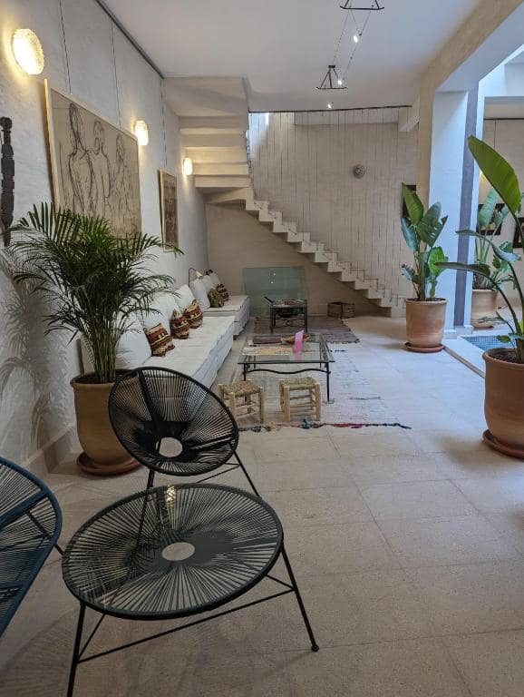 Un salon du patio, dessins encadrés et fauteuils en fil tendu