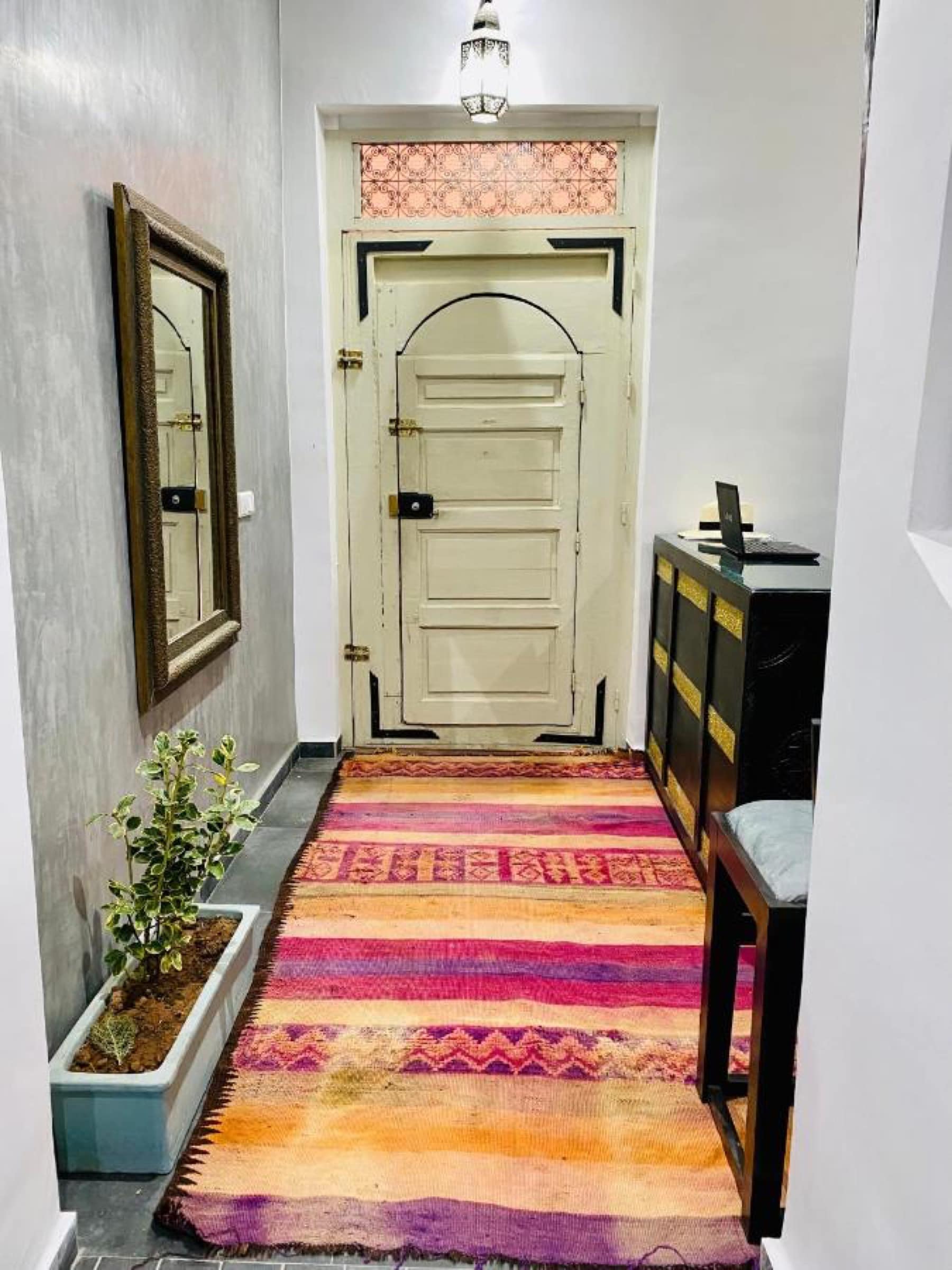 Un couloir aux tapis, porte ancienne et tadelakt gris