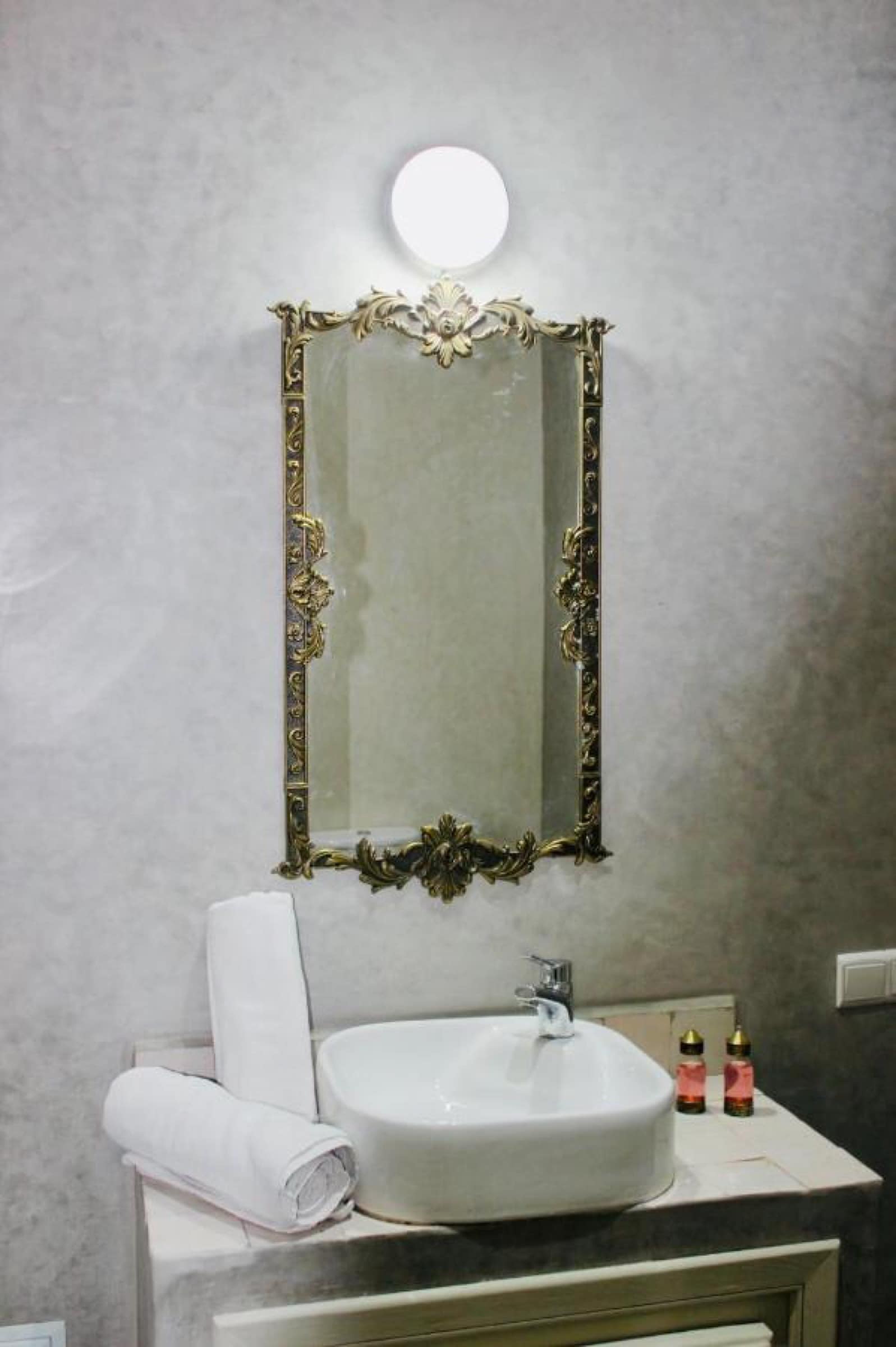 Une salle de bains en tadelakt, miroir doré ciselé