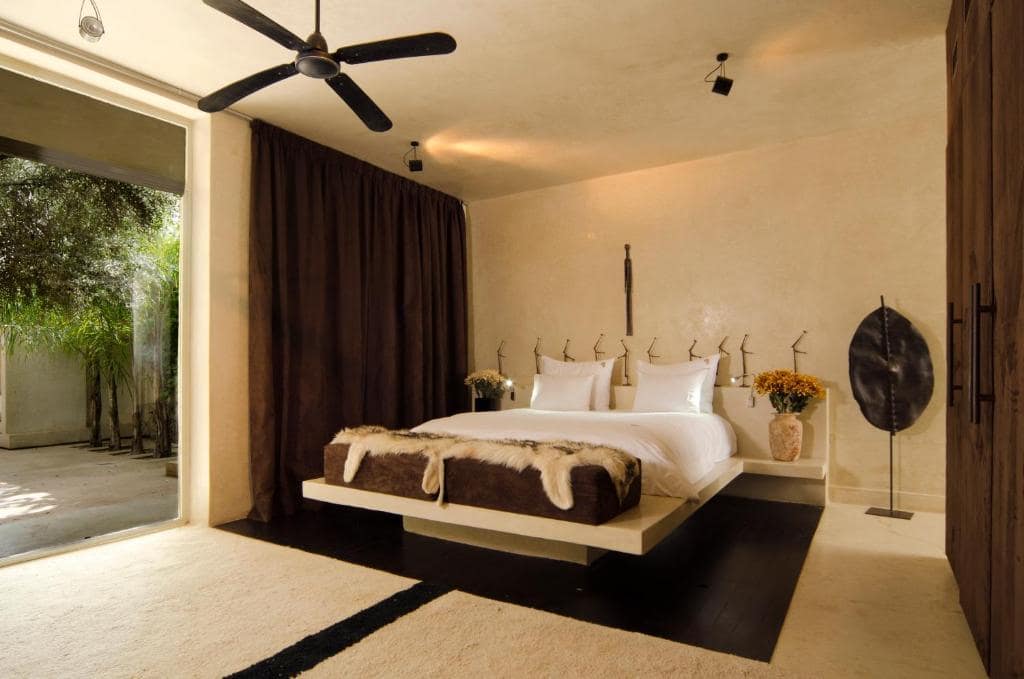 Une chambre au lit suspendu, ouverte sur le jardin