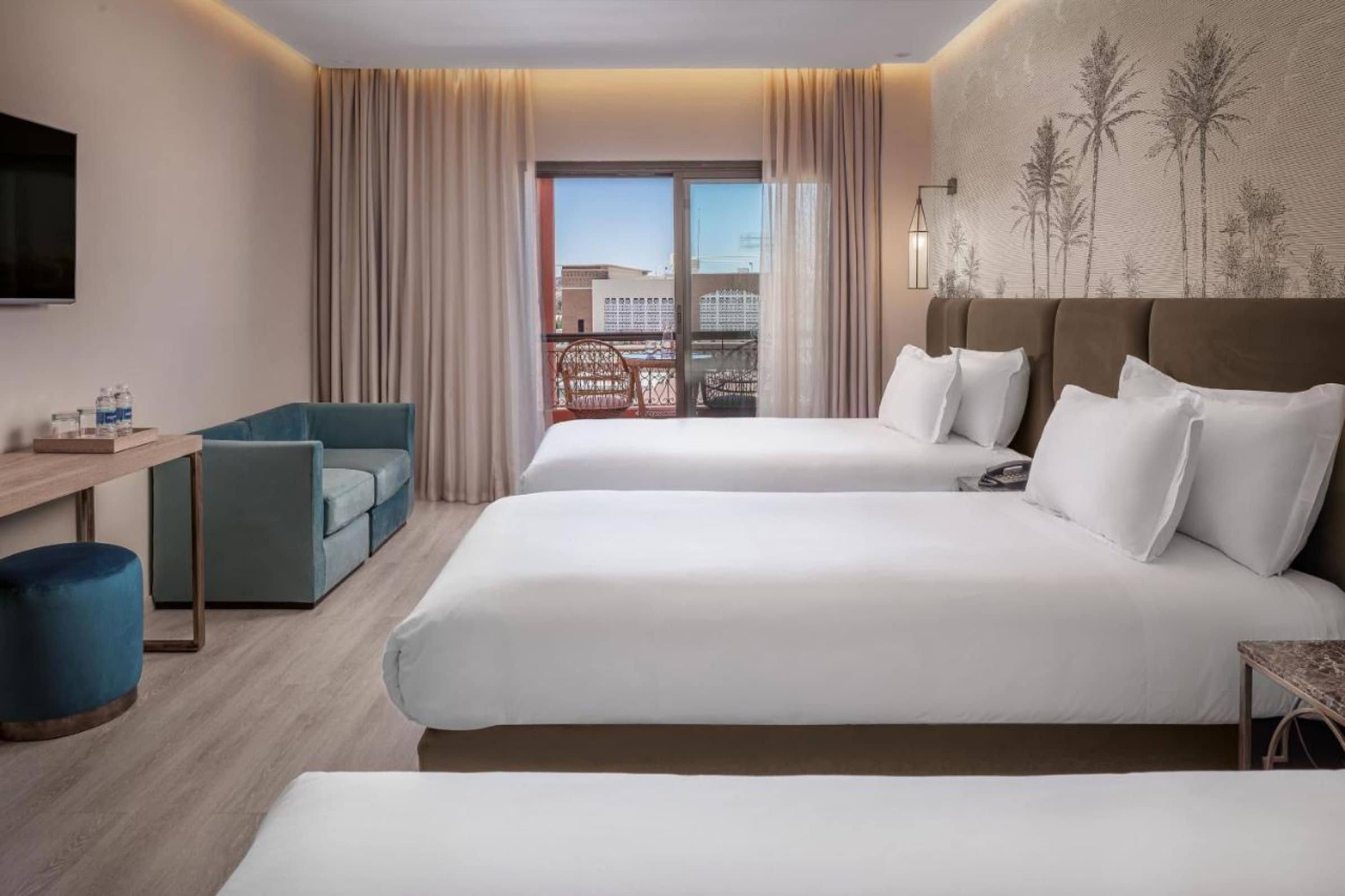 Une chambre familiale à plusieurs lits, fresque de palmiers