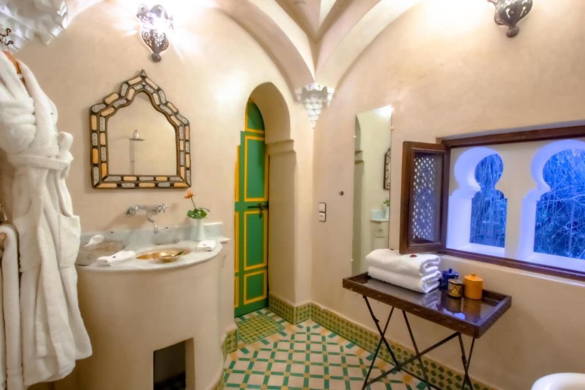 Une salle d'eau en tadelakt, porte peinte et fenêtre à arcs jumeaux