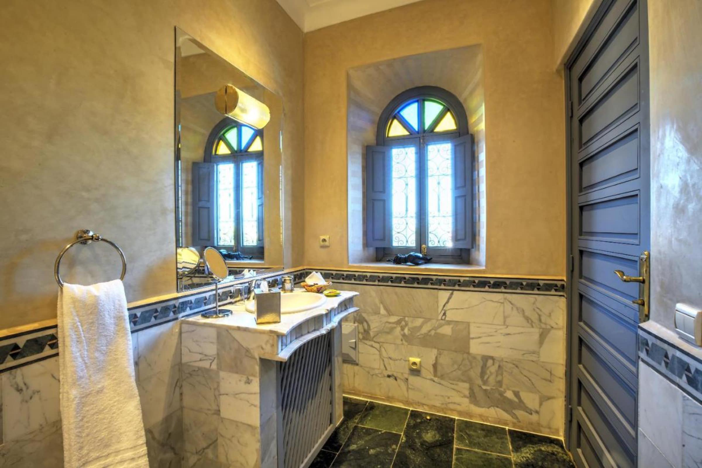 Une salle de bains en marbre, fenêtre à vitraux