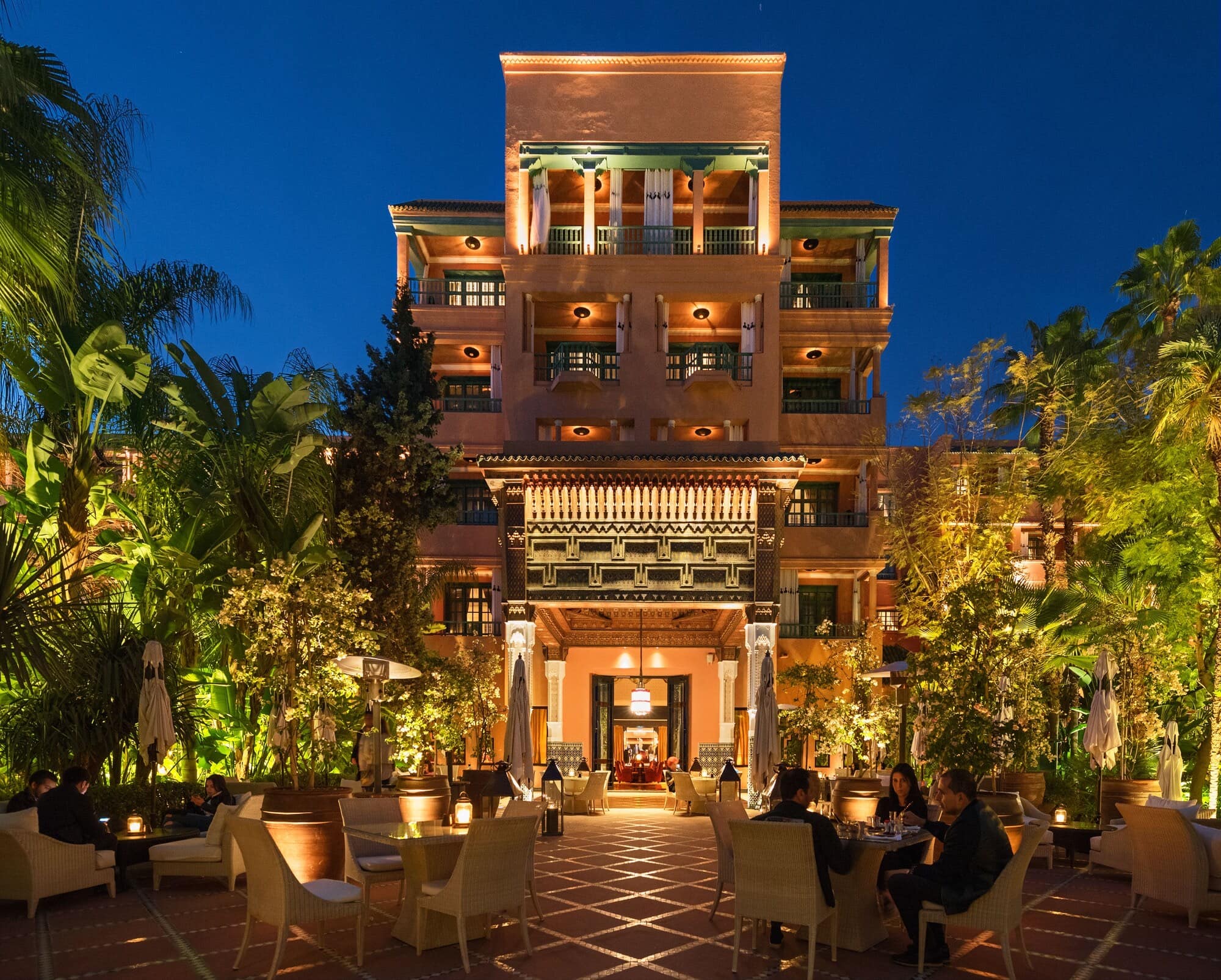 La façade Art déco illuminée, vue des jardins au soir