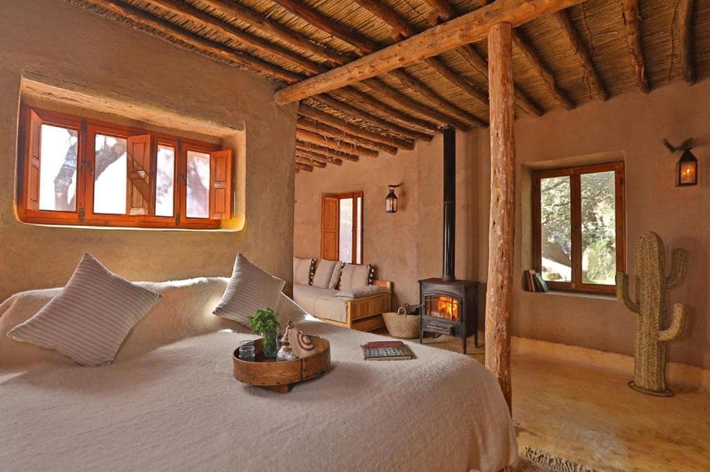 Un lodge en pisé, poêle à bois et lanterne pour la nuit