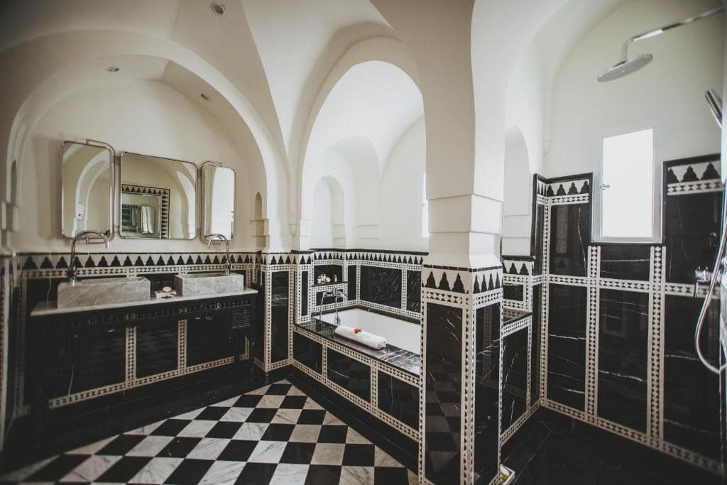 Une salle de bains de zellige noir et blanc, sous voûtes