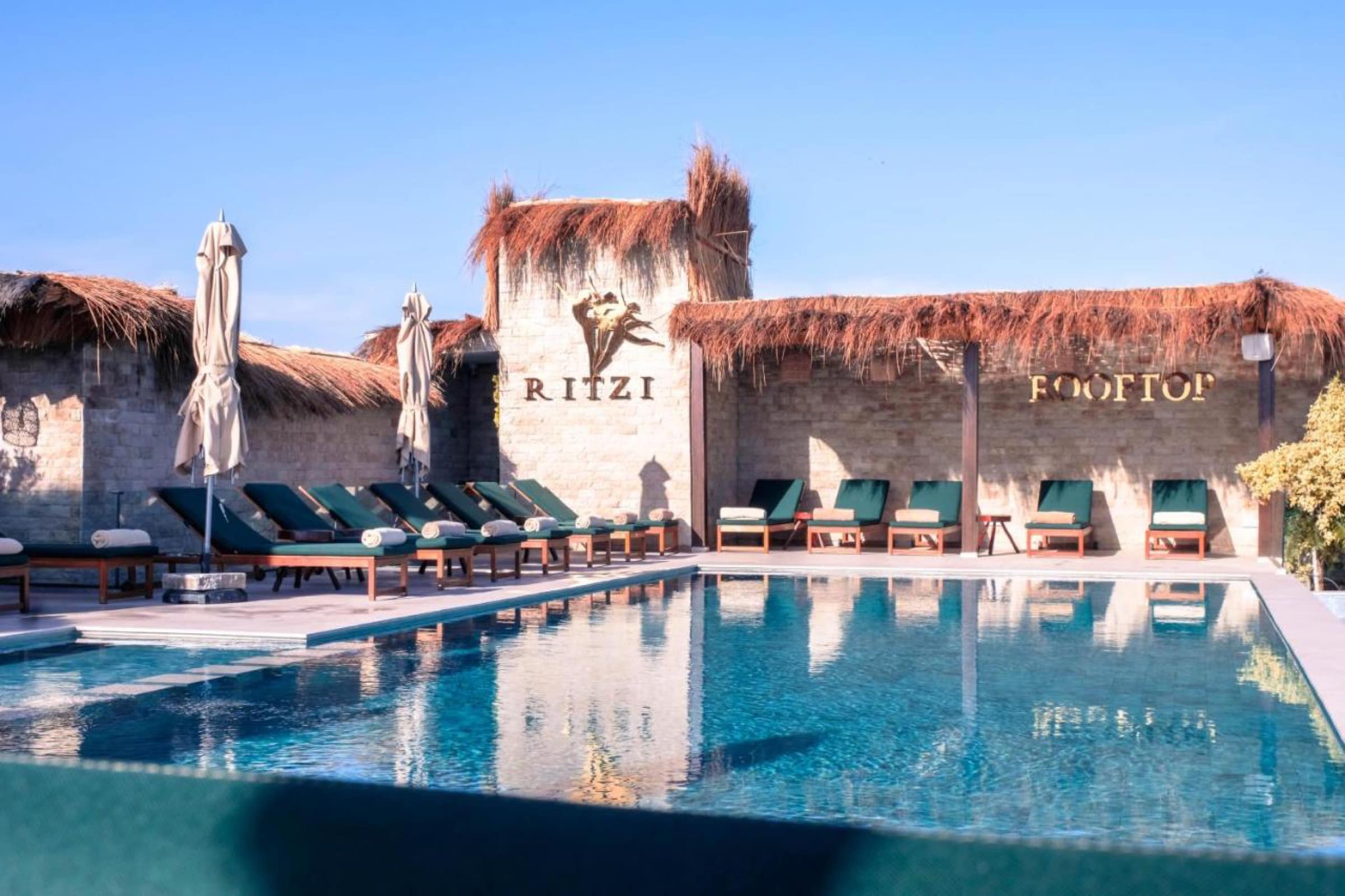 Le Ritzi Rooftop, bar et transats au bord de la piscine du toit