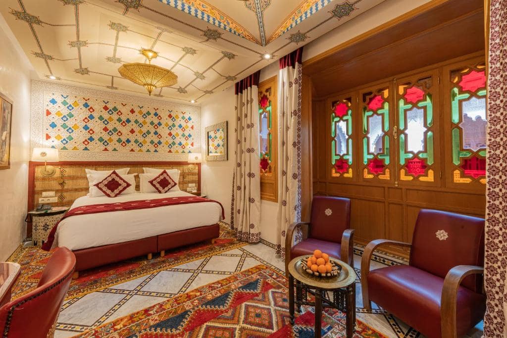 Une chambre sous plafond peint et vitraux colorés