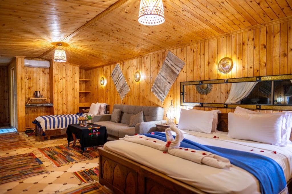 Une chambre lambrissée de bois, tapis et lumière de montagne