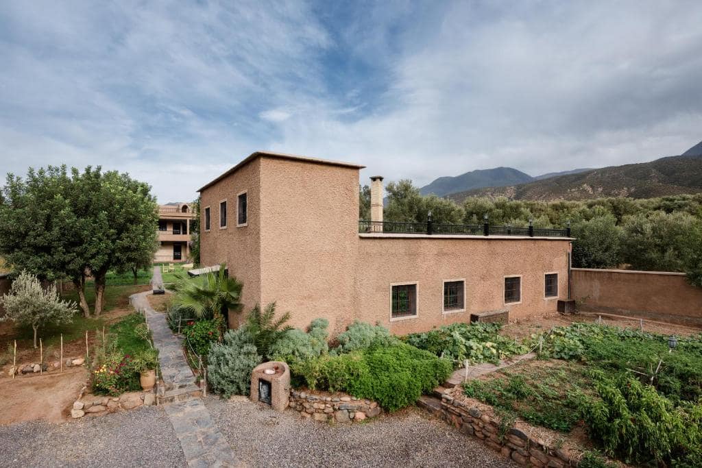 Le bâtiment de pisé et son potager, en contrebas des cimes