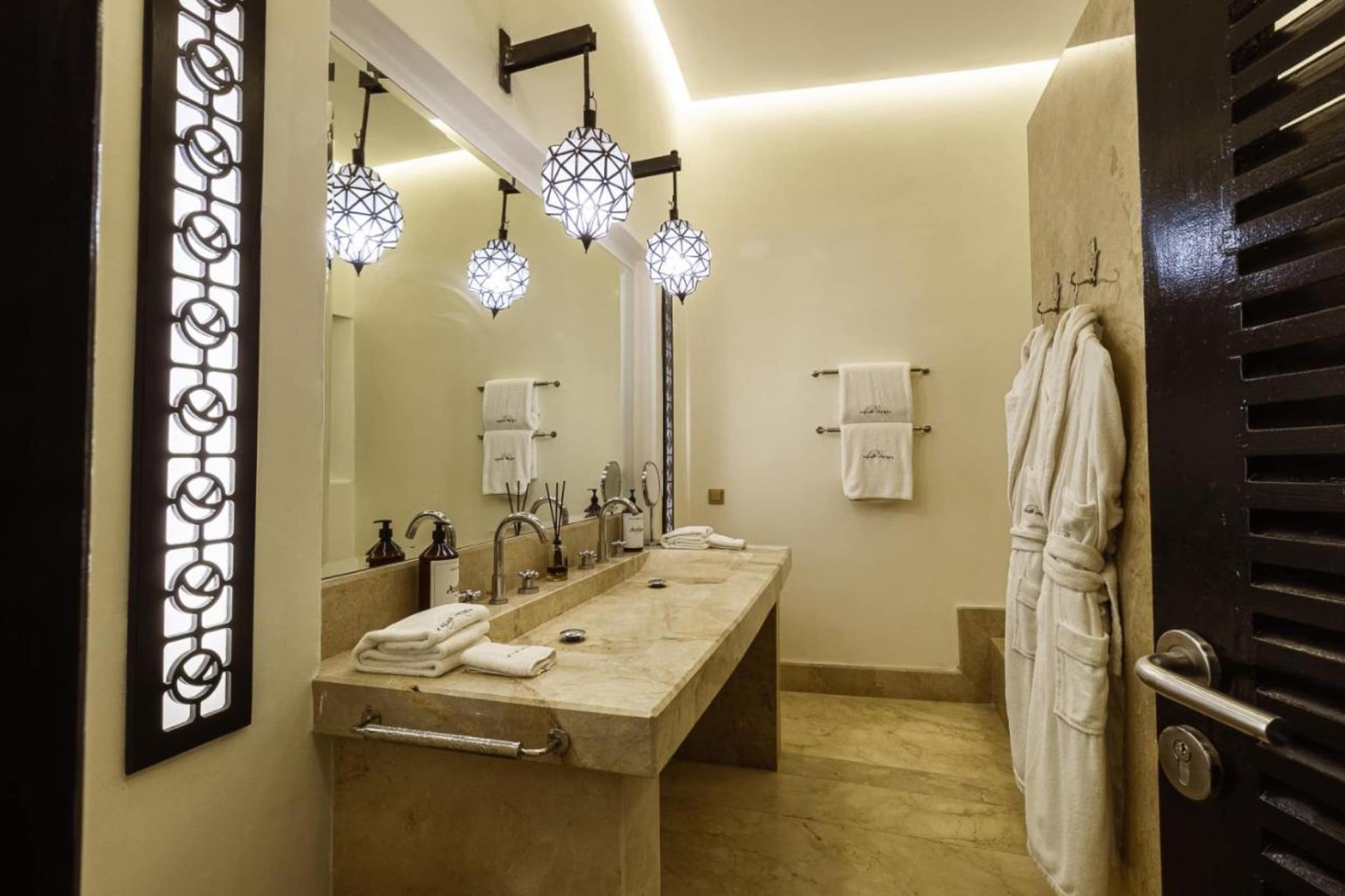 Une salle de bains en marbre, lanternes et moucharabieh