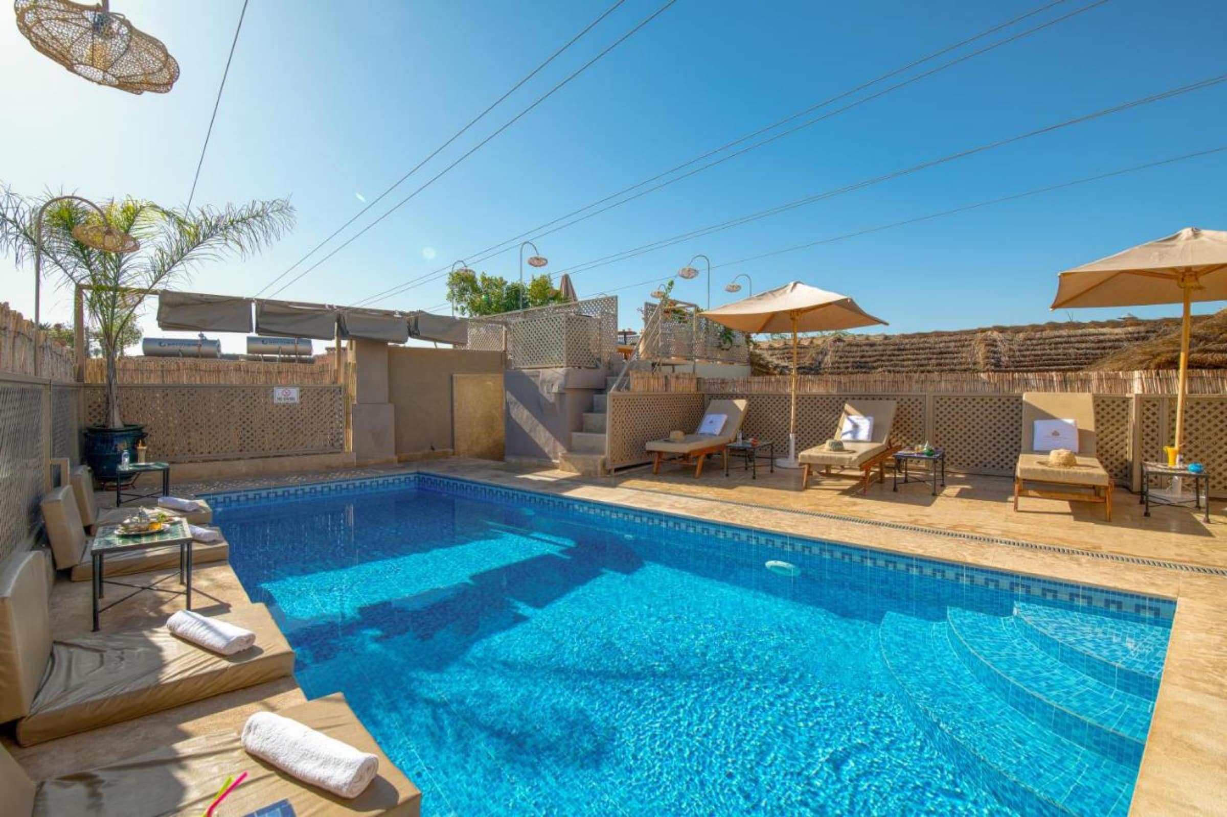 La piscine chauffée de la terrasse, transats et parasols