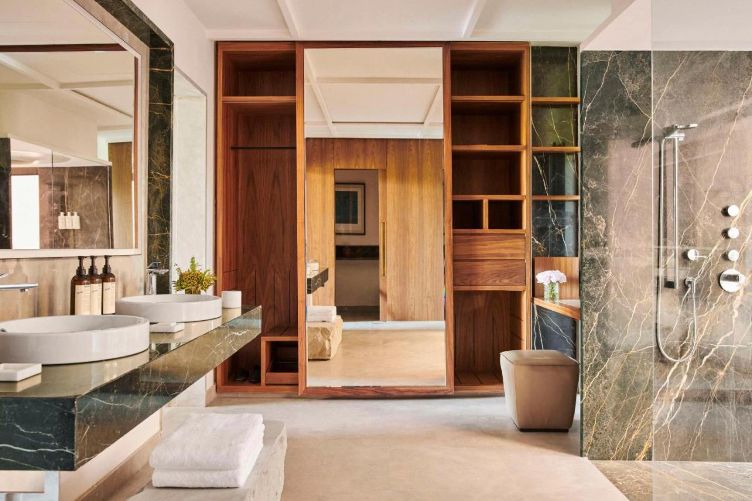 Une salle de bains en marbre vert et noyer, douche et dressing