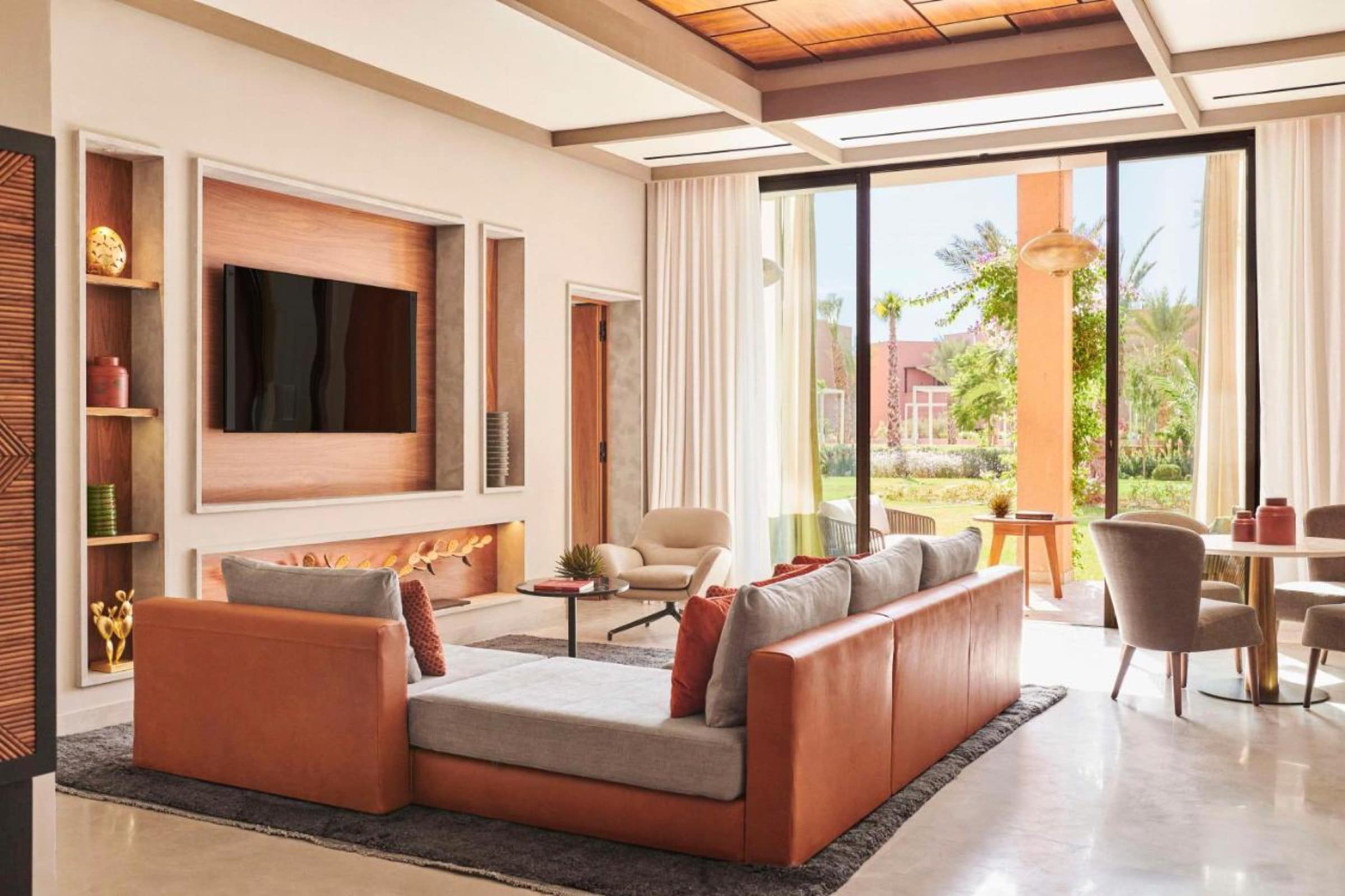 Le salon d'une villa, cheminée et baies sur la palmeraie