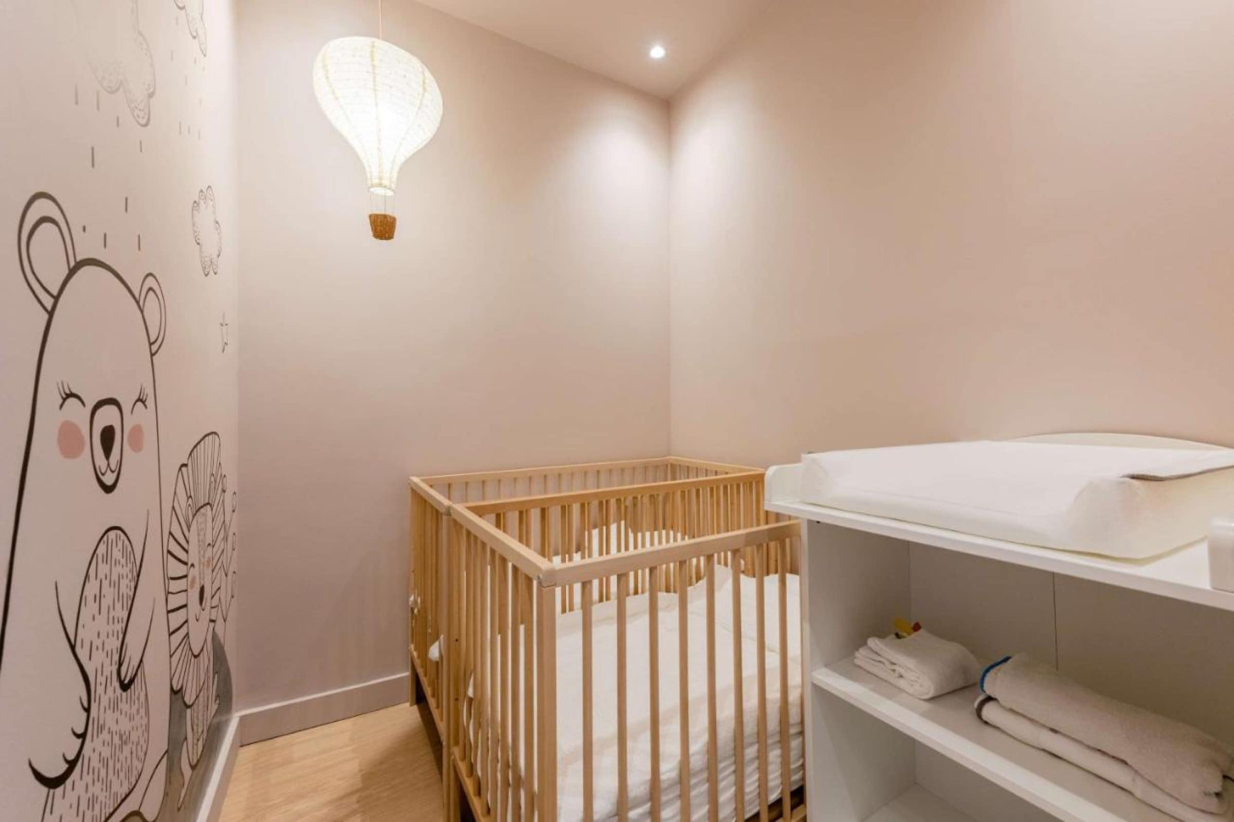 L'espace bébé du club enfants, lit à barreaux et fresque