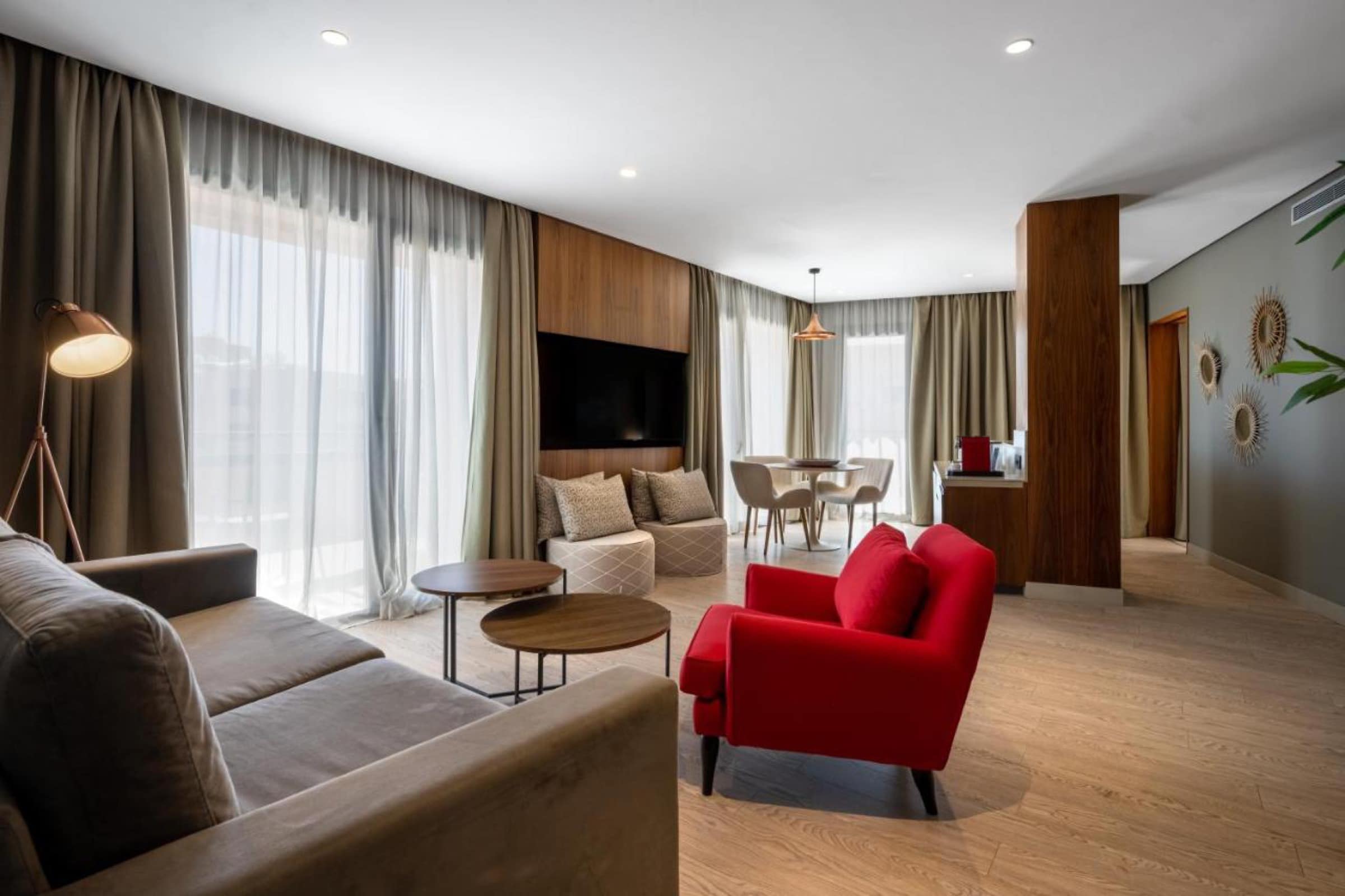 Le salon d'une suite, lignes contemporaines et fauteuil rouge