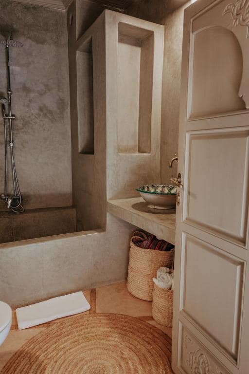 Une salle d'eau en tadelakt, vasque peinte et douche ouverte