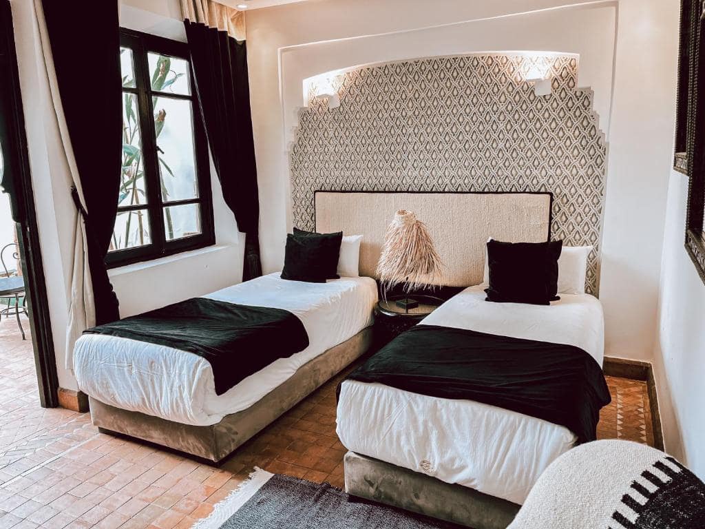 Une chambre à deux lits, tête de lit en zellige clair