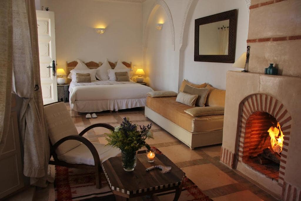Une chambre, daybed et cheminée d'angle en pisé