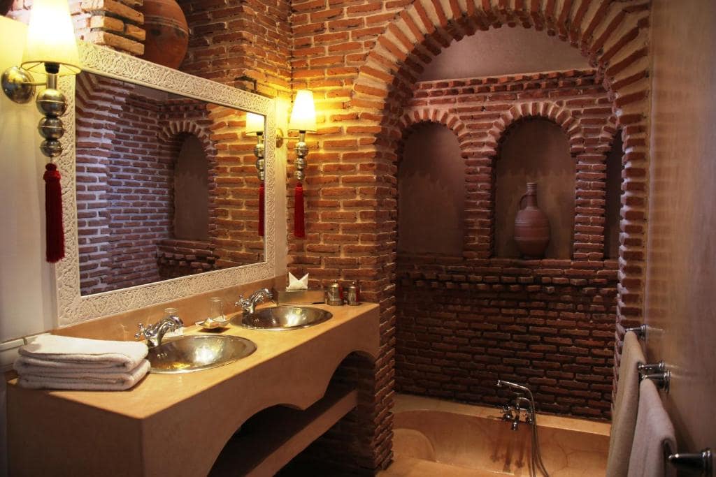 Une salle d'eau voûtée de brique, double vasque et baignoire