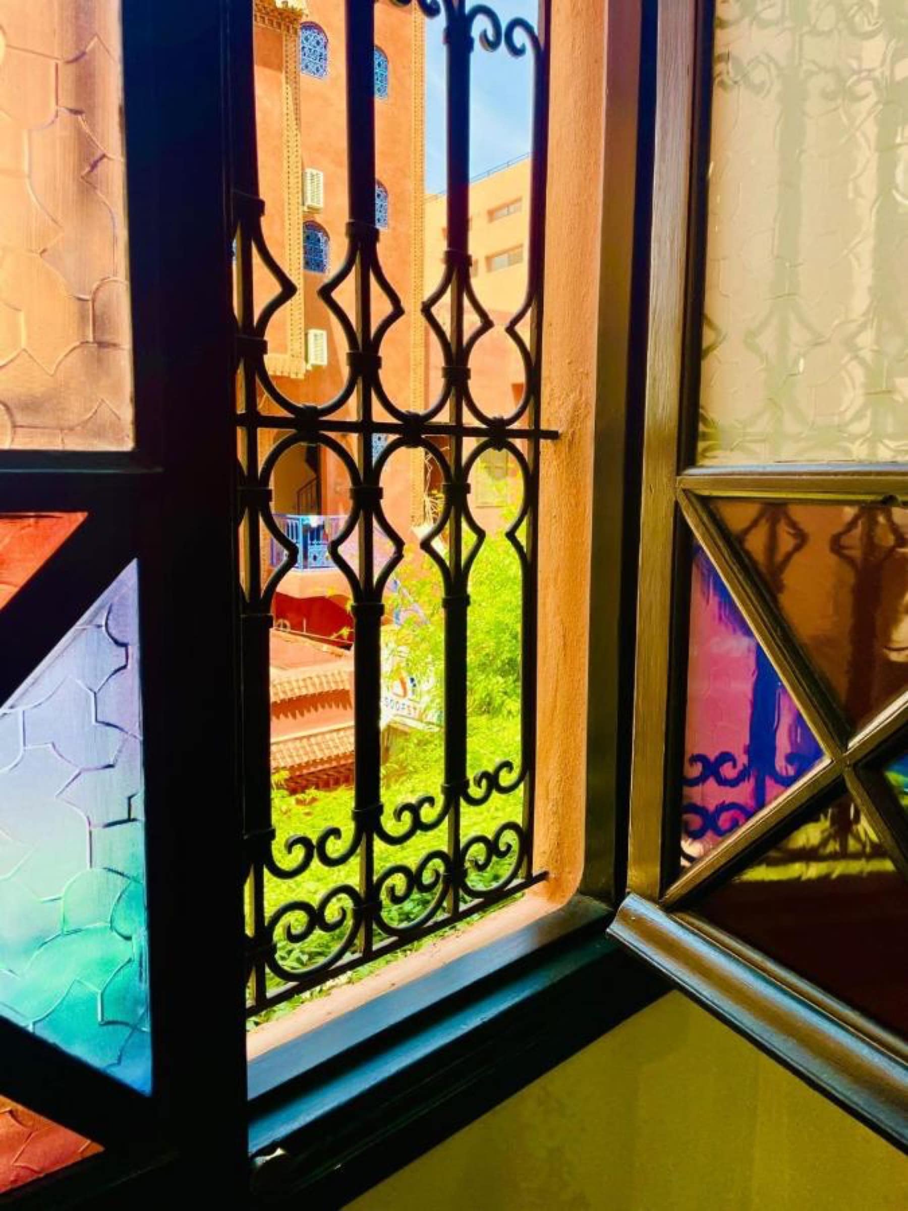 Une fenêtre à vitraux ouverte sur le jardin intérieur