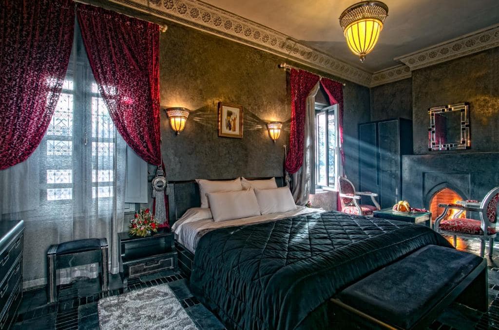 Une chambre en tadelakt gris, rideaux grenat et cheminée