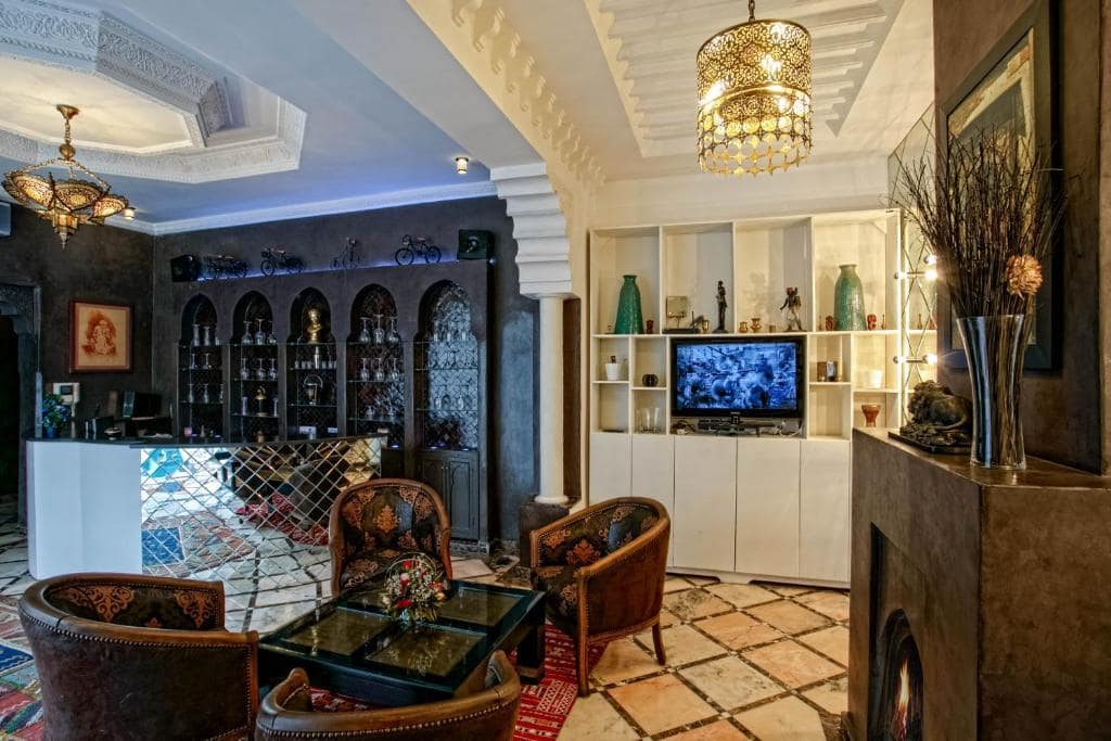 Le salon à cheminée, bar de zellige et fauteuils bas