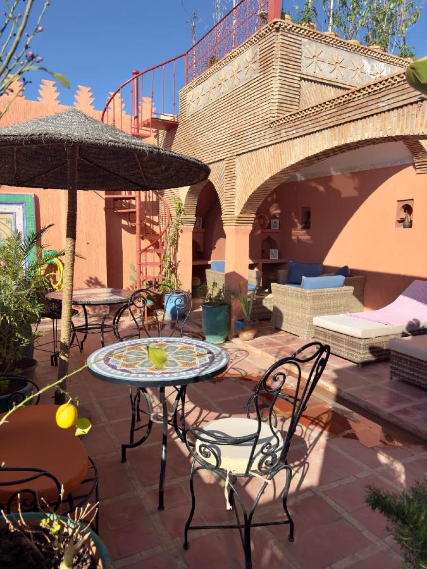 La terrasse et son parasol de palme, escalier hélicoïdal