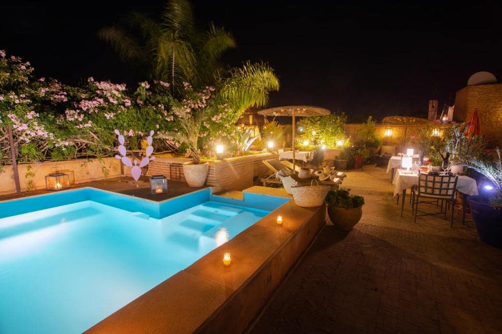 Le toit le soir, piscine éclairée et tables dressées à la bougie