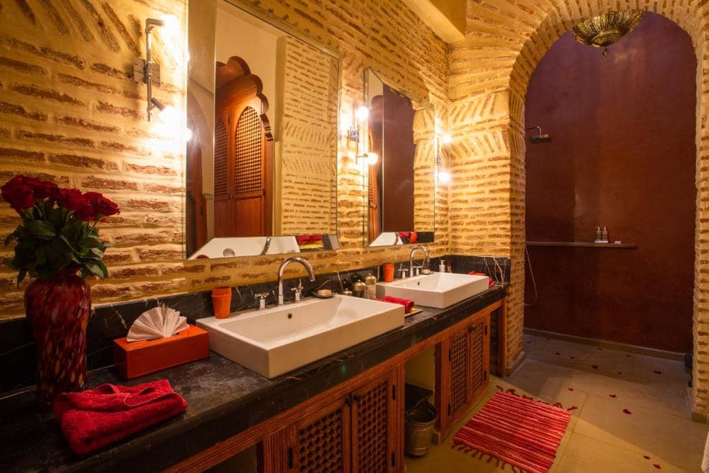 Une salle d'eau à double vasque, murs de brique et douche en tadelakt