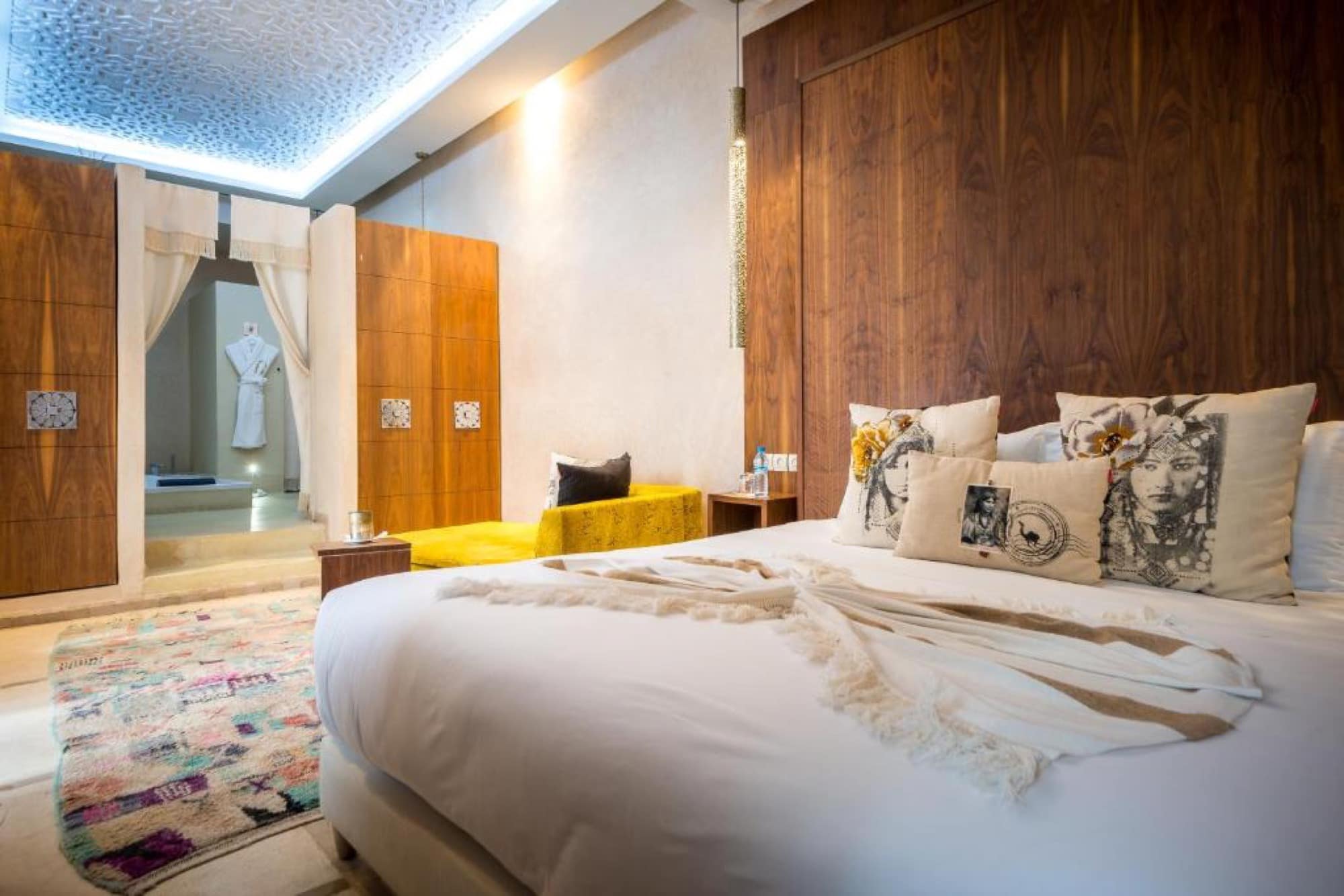 Une chambre, tête de lit en noyer et tapis berbère