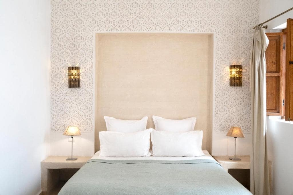 Une chambre, tête de lit en niche et appliques ciselées
