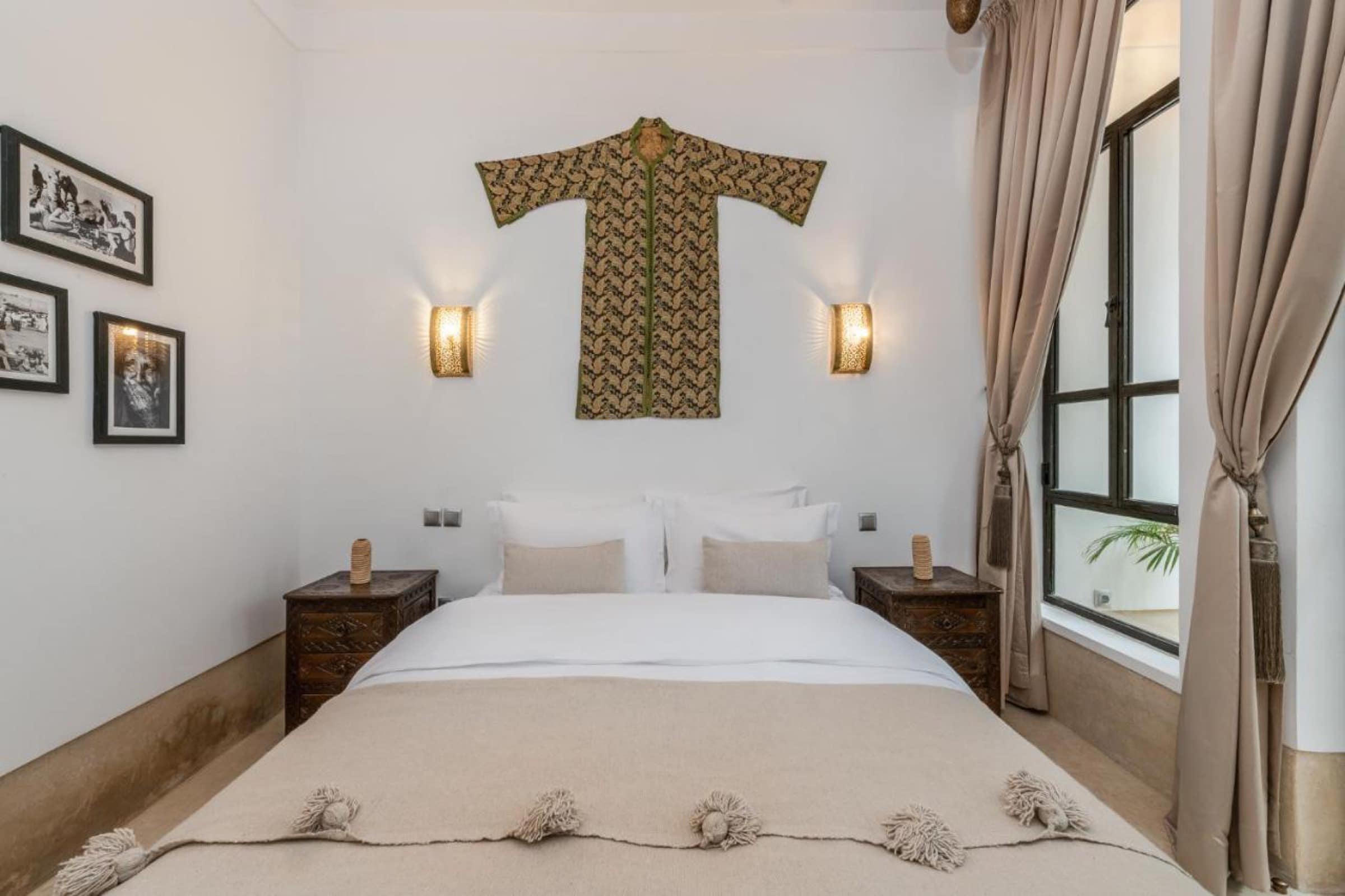 Une chambre épurée, caftan ancien encadré au mur