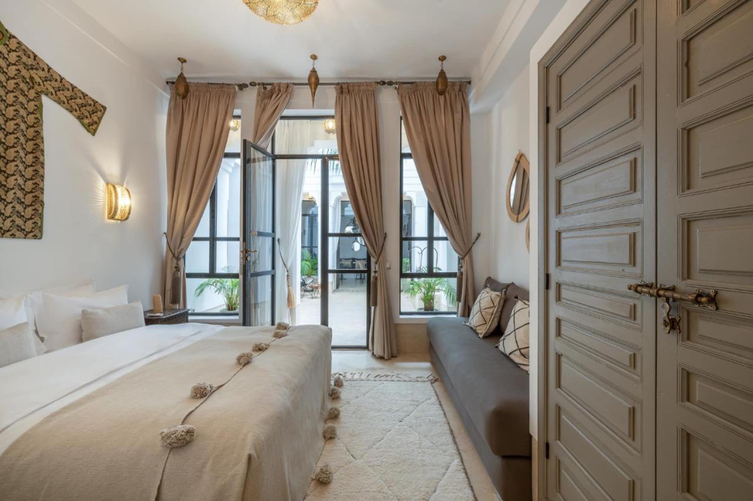 Une chambre ouverte sur le patio, banquette et pompons