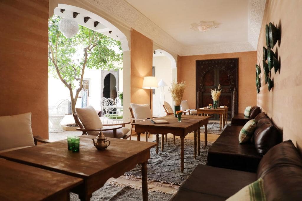 Le salon ouvert sur le patio, banquettes et portes sculptées