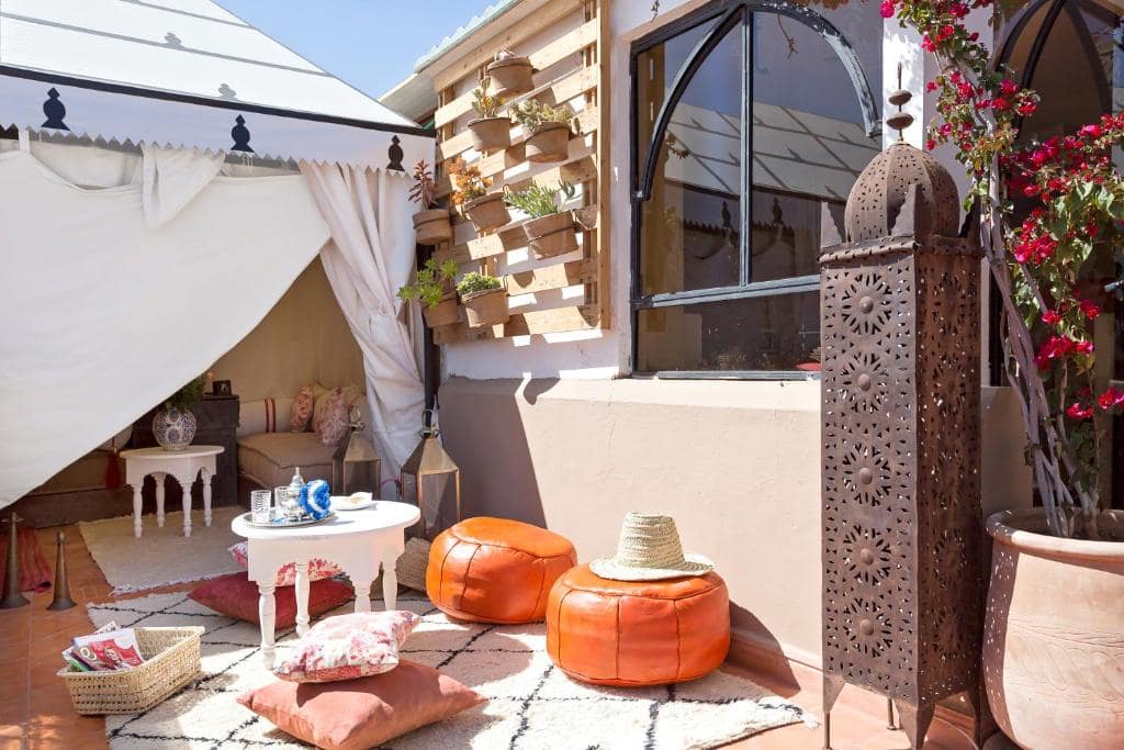 Un coin tente sur la terrasse, poufs de cuir et lanterne ajourée