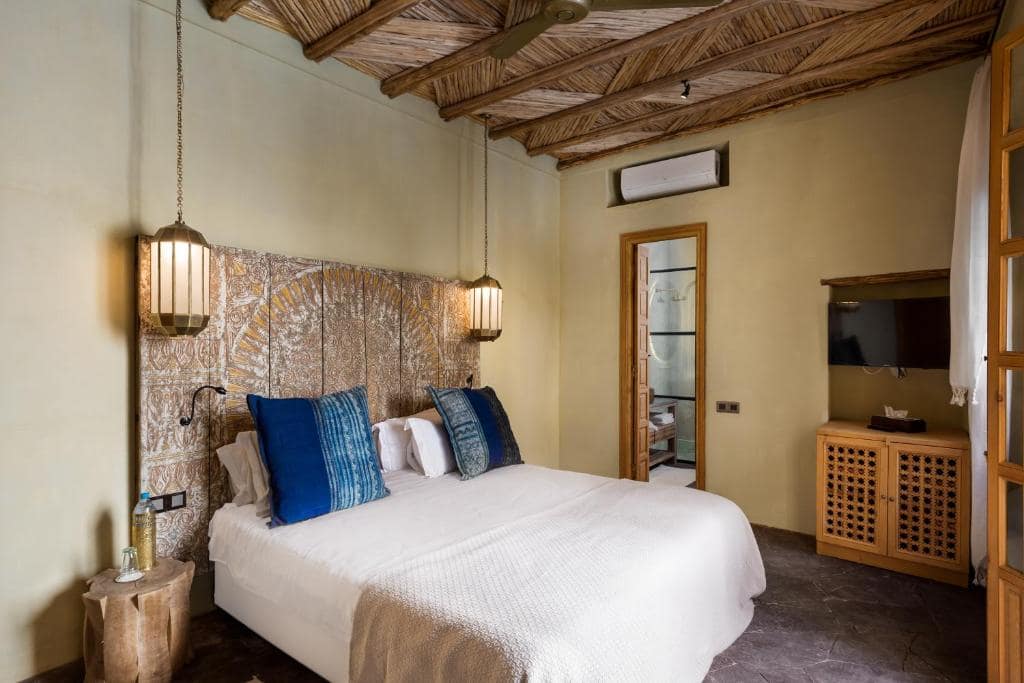Une chambre, tête de lit sculptée et plafond de roseaux