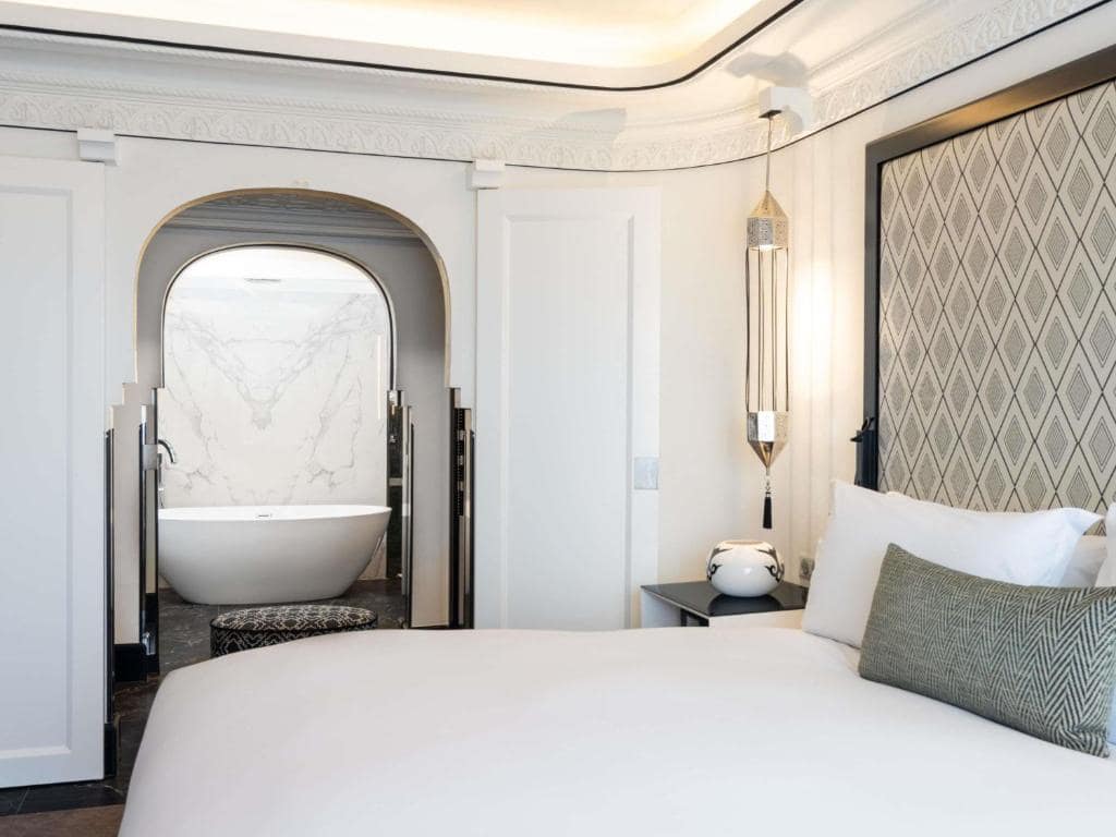 Une chambre, sa baignoire et sa tête de lit en zellige