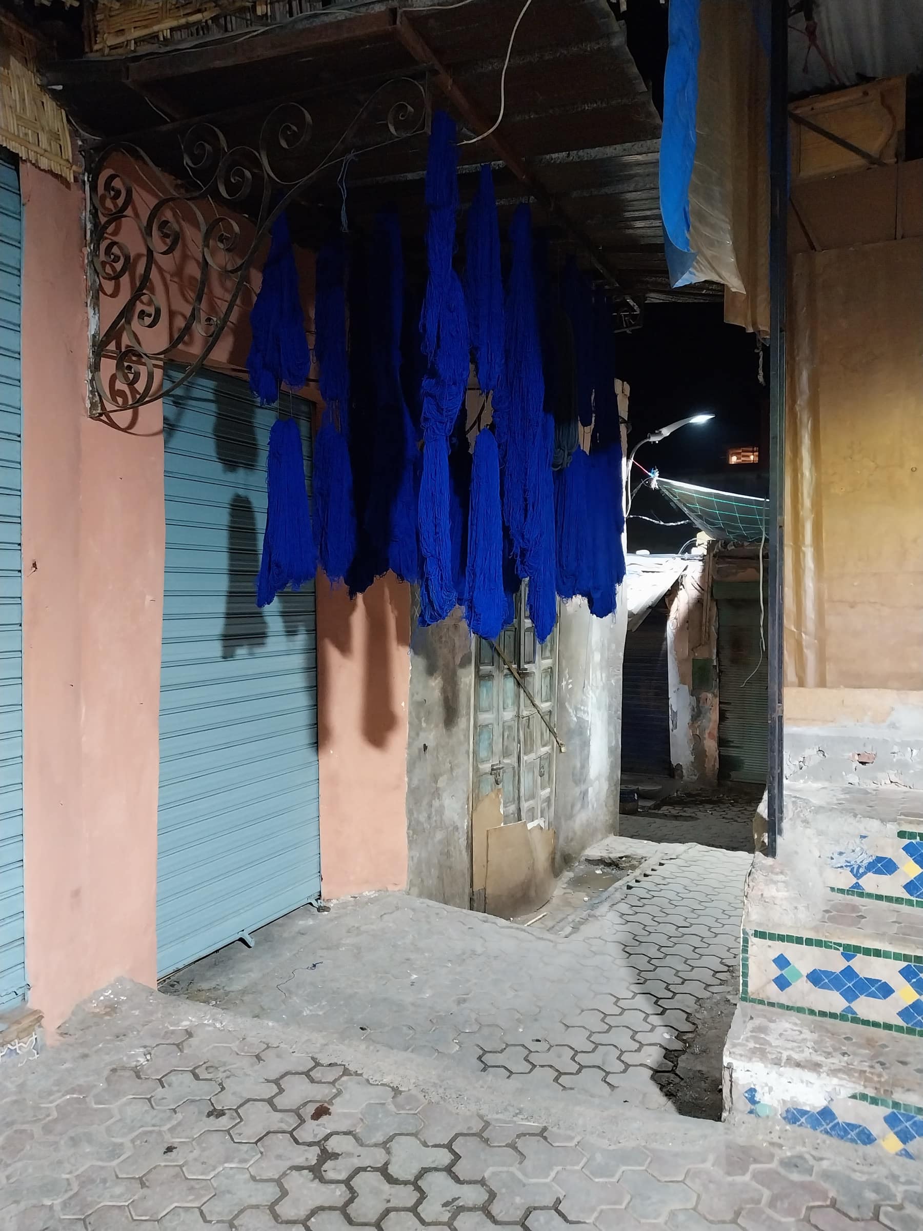 Écheveaux de laine teinte bleu indigo suspendus à sécher dans une ruelle du souk Sebbaghine à Marrakech