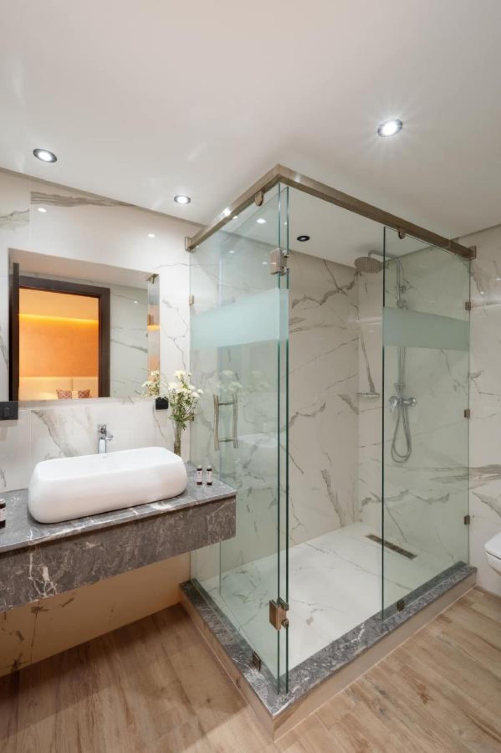 Une salle de bains en marbre, douche à l'italienne vitrée