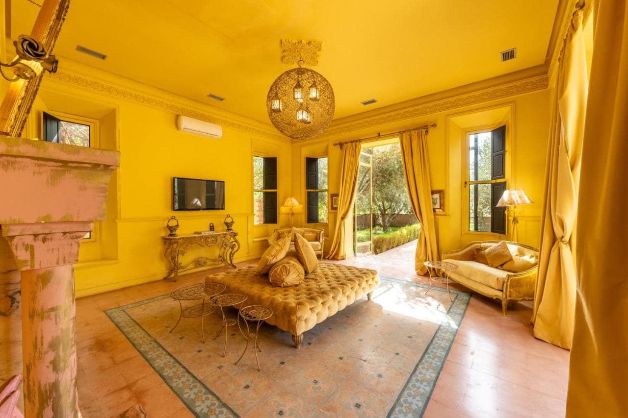 Un salon jaune vif, cheminée en tadelakt et lustre en filigrane