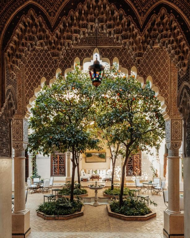 Un des trois patios, orangers et fontaine sous des arches de plâtre ciselé