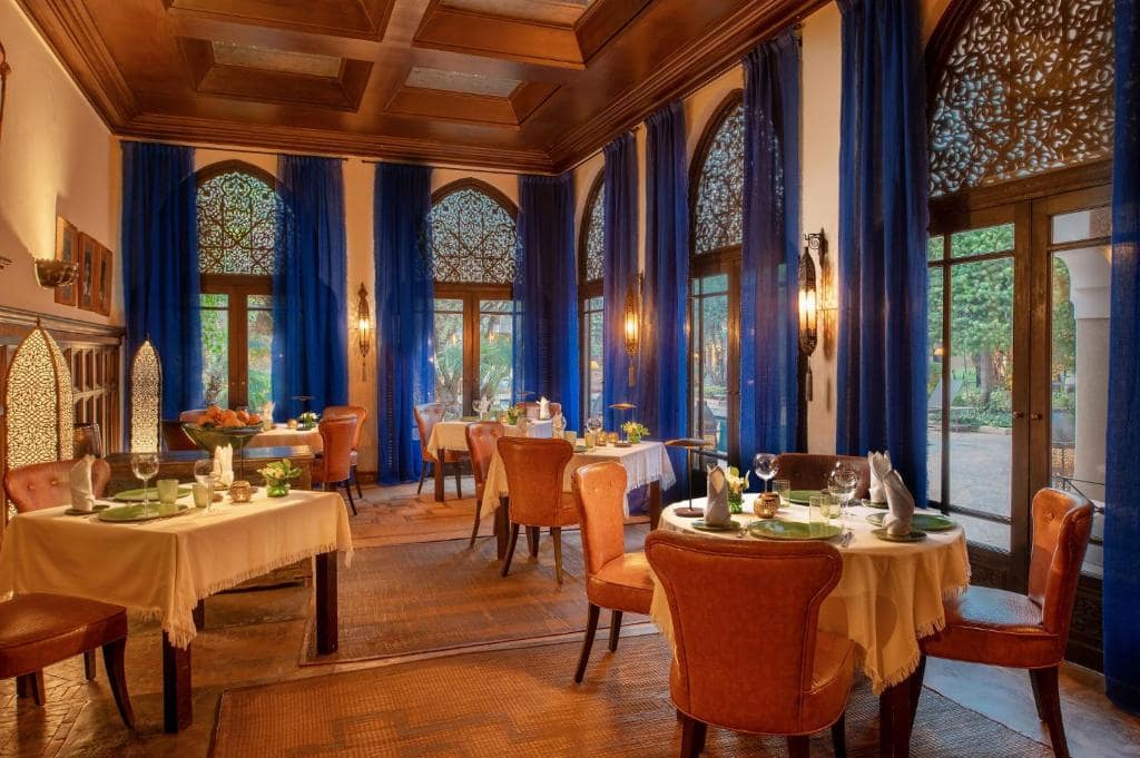 La salle du restaurant, hauts rideaux bleus et fenêtres à moucharabieh
